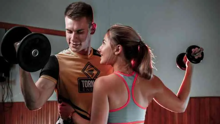 kobieta i mężczyzna ćwiczący z oporem, uśmiechnięci, zdrowi