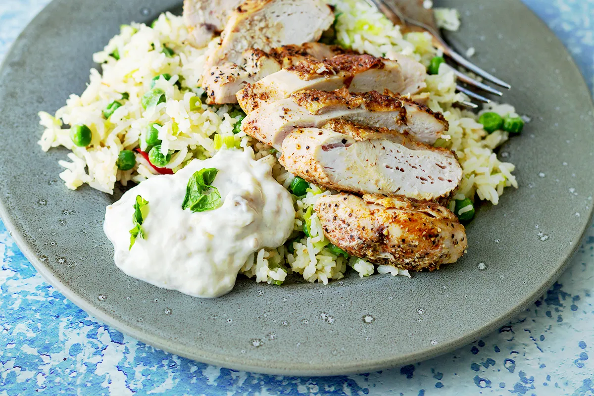 Pyszny kurczak z ryżem i groszkiem, świetny pomysł na to, co można zrobić z ugotowanego ryżu. Podane z sosem jogurtowym.