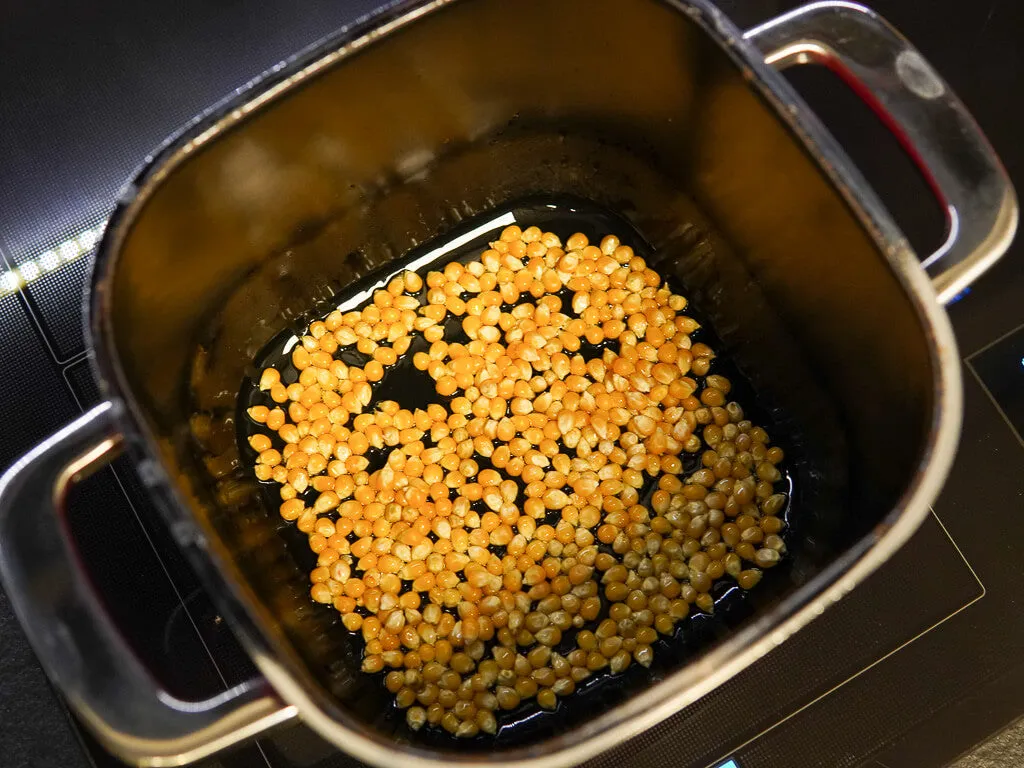 Garnek z grubym dnem i ziarna kukurydzy do popcornu