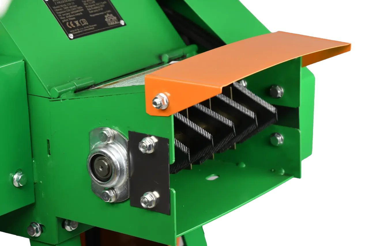 Zielony rozdrabniacz do kompostu z pomarańczową osłoną i ostrymi nożami, gotowy do pracy.