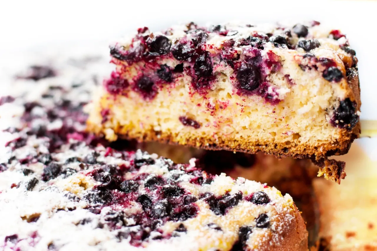 Pyszny biszkopt z jagodami i kruszonką, posypany cukrem pudrem. Idealny na deser.