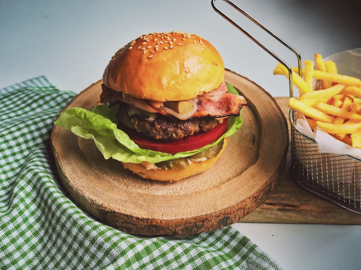 Soczysty burger z bekonem i frytkami. Idealny przykład, jak zrobić dobre burgery.
