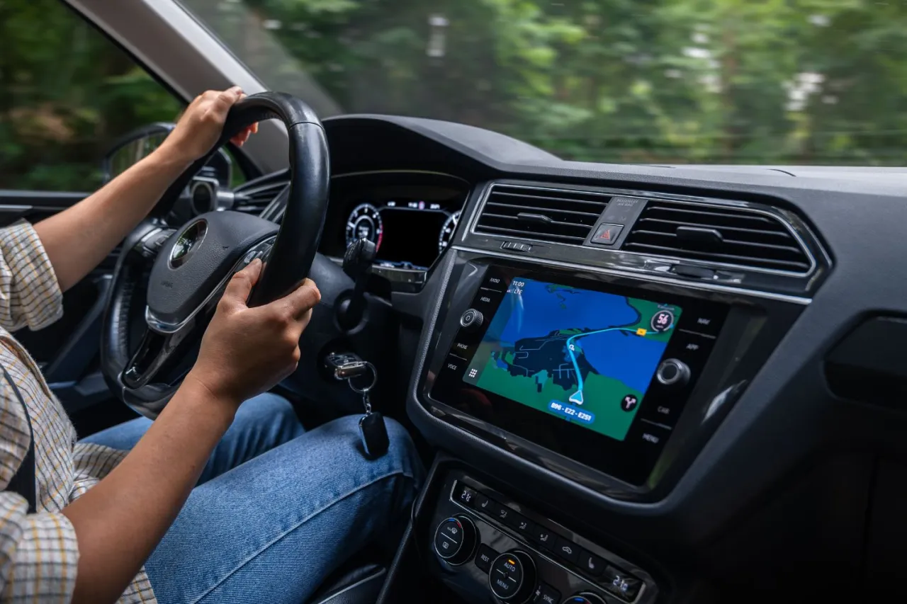 Kierowca wpatruje się w ekran nawigacji, gdzie widoczna jest mapa. To dobry moment, by dowiedzieć się, jak zaktualizować mapę w nawigacji.