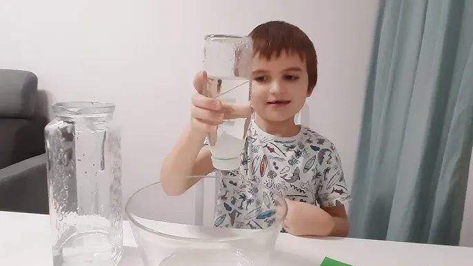 Dziecko wykonujące eksperyment z napięciem powierzchniowym wody