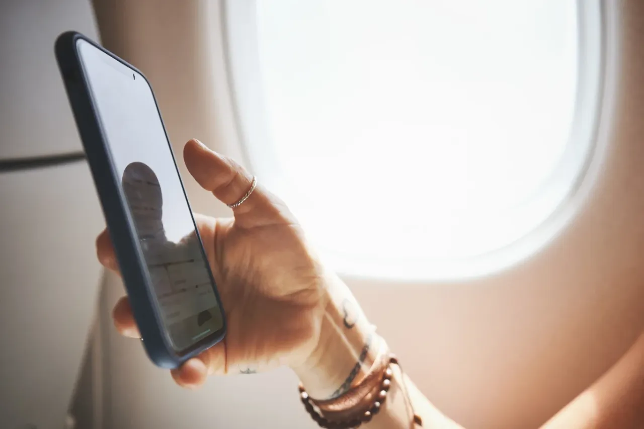 osoba korzystająca z telefonu w samolocie, szybkie ładowanie telefonu