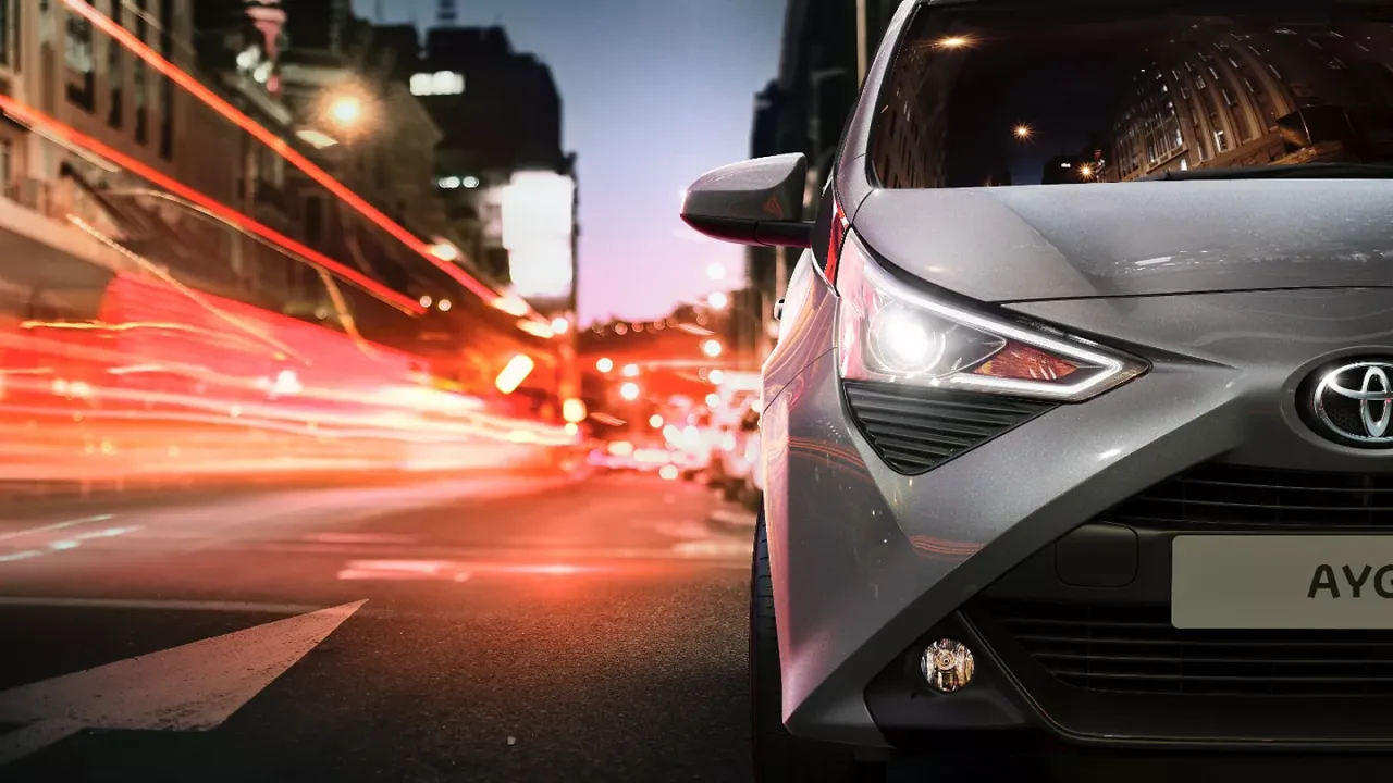 Szare Toyota Aygo 1.0 na tle rozmazanych świateł miasta. Jaki olej silnikowy do tego modelu?