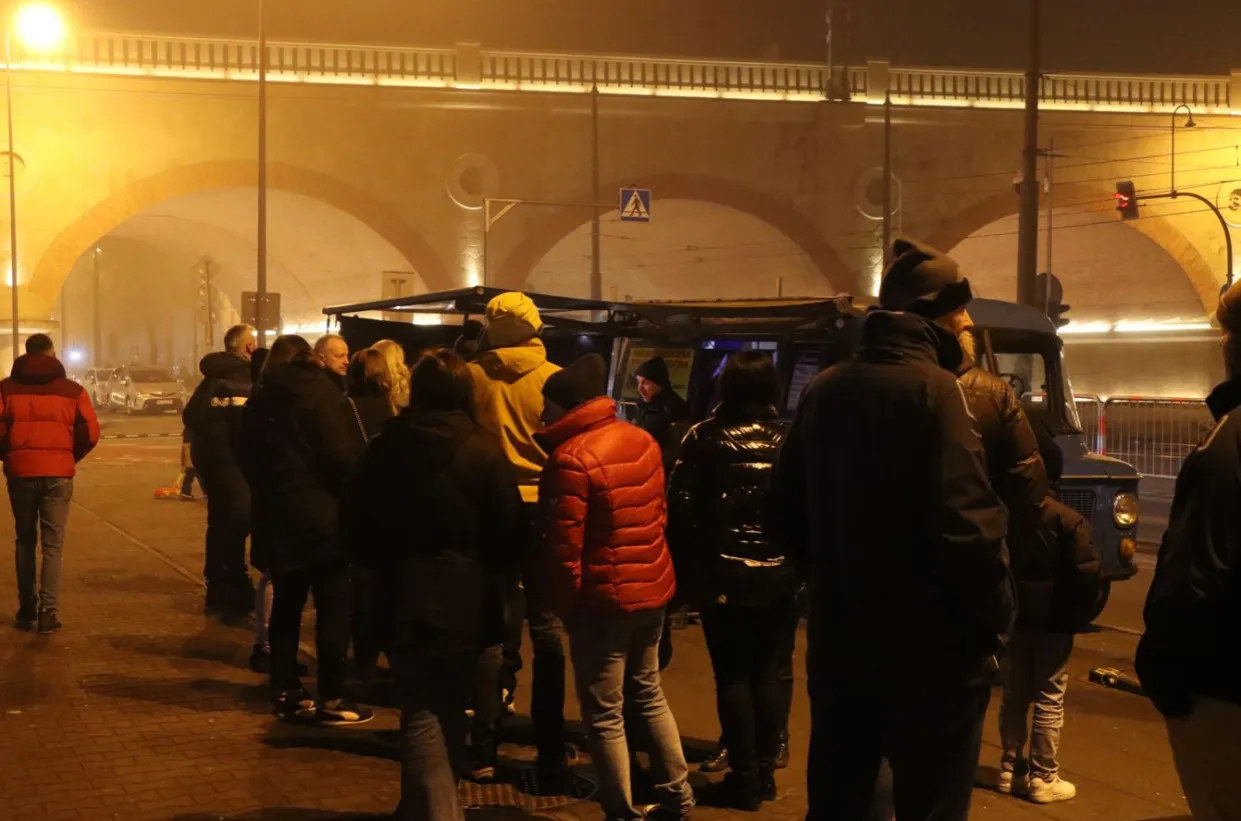 Kolejka po kiełbasę z niebieskiej Nyski pod mostem. Ludzie czekają na ciepły posiłek w zimowy wiecz&oacute;r.