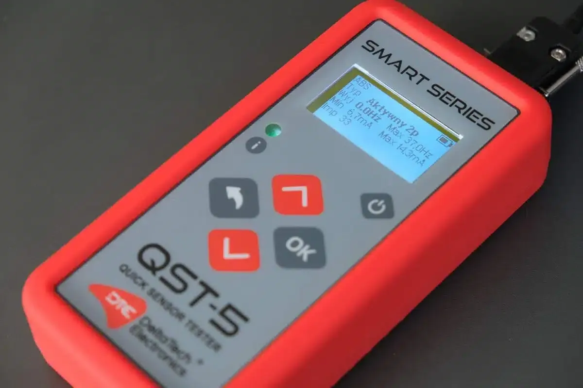 Tester QST-5 do szybkiego sprawdzania czujnika ABS. Na ekranie widoczne parametry: typ, min/max częstotliwość i natężenie prądu.