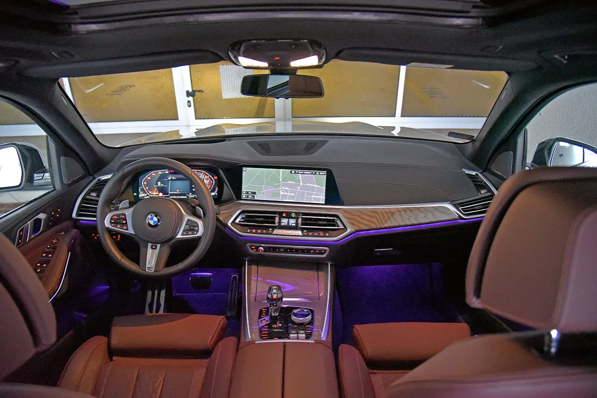 Wnętrze BMW X5, widok z przodu. Sk&oacute;rzana tapicerka, duży ekran nawigacji i cyfrowe zegary. To wnętrze, kt&oacute;re można znaleźć na BMW X5 wiki.
