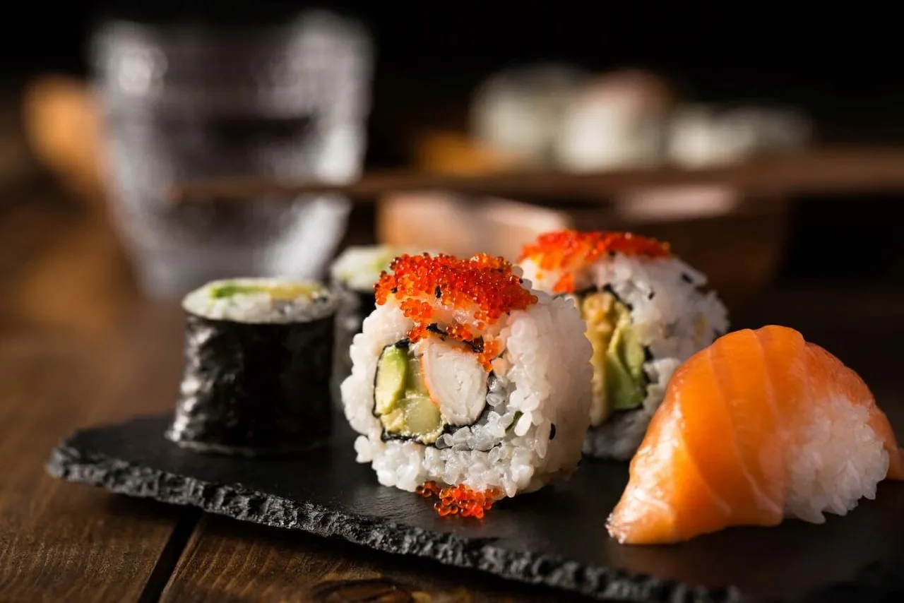 Pyszne sushi: rolka z kawiorową posypką, nigiri z łososiem i maki z awokado. Idealne na wieczór z przyjaciółmi.