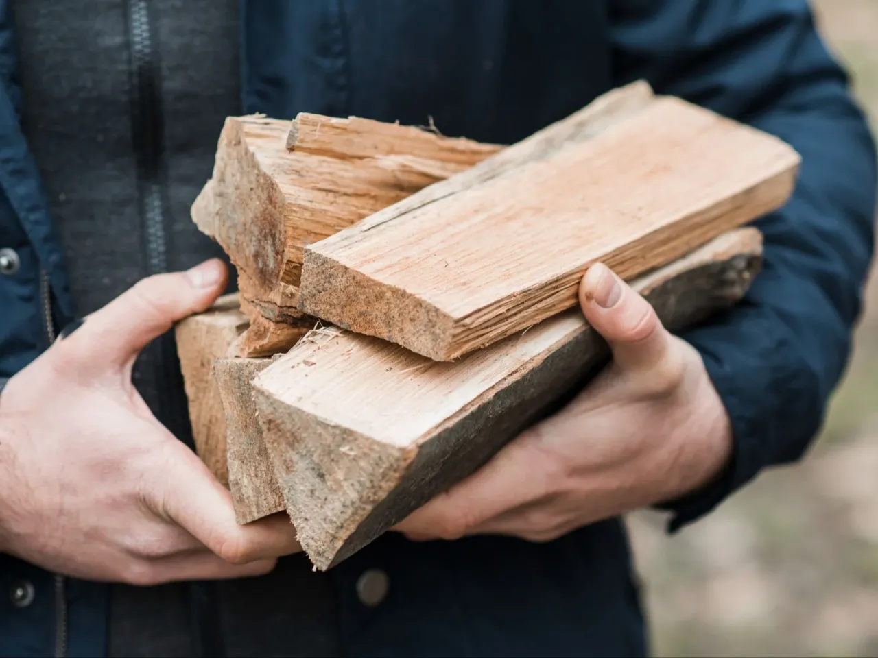 Ręce trzymające pocięte drewno konstrukcyjne. Zastanawiasz się, ile kosztuje kubik drewna konstrukcyjnego?