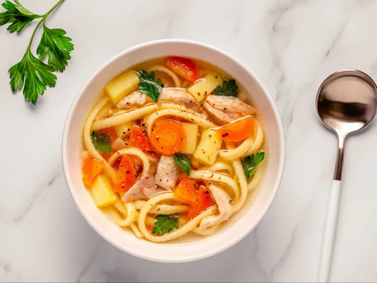 Rozgrzewająca zupa z kurczakiem, makaronem, ziemniakami i marchewką &ndash; idealne danie, co można zjeść na obiad.