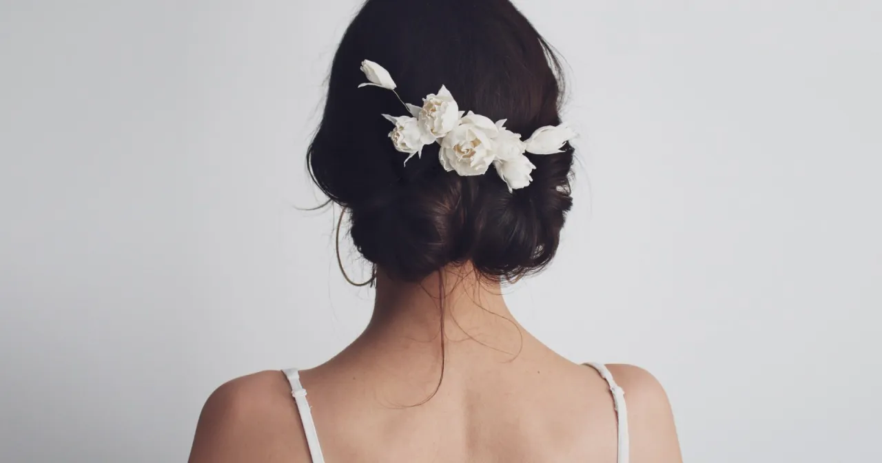 Eleganckie fryzury na wesele dla średnich włos&oacute;w: upięcie z białymi kwiatami.