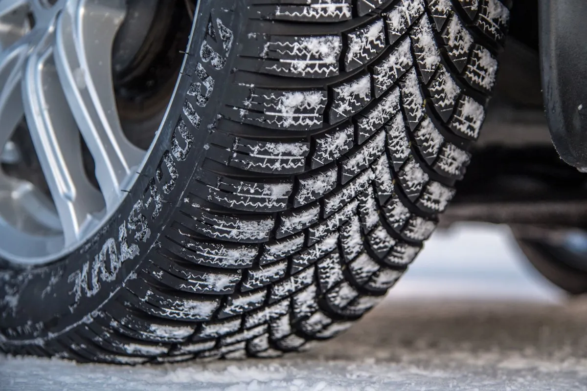 Opony zimowe pokryte śniegiem na feldze. Zastanawiasz się, jakie opony zimowe wybrać? Ten bieżnik zapewni przyczepność.