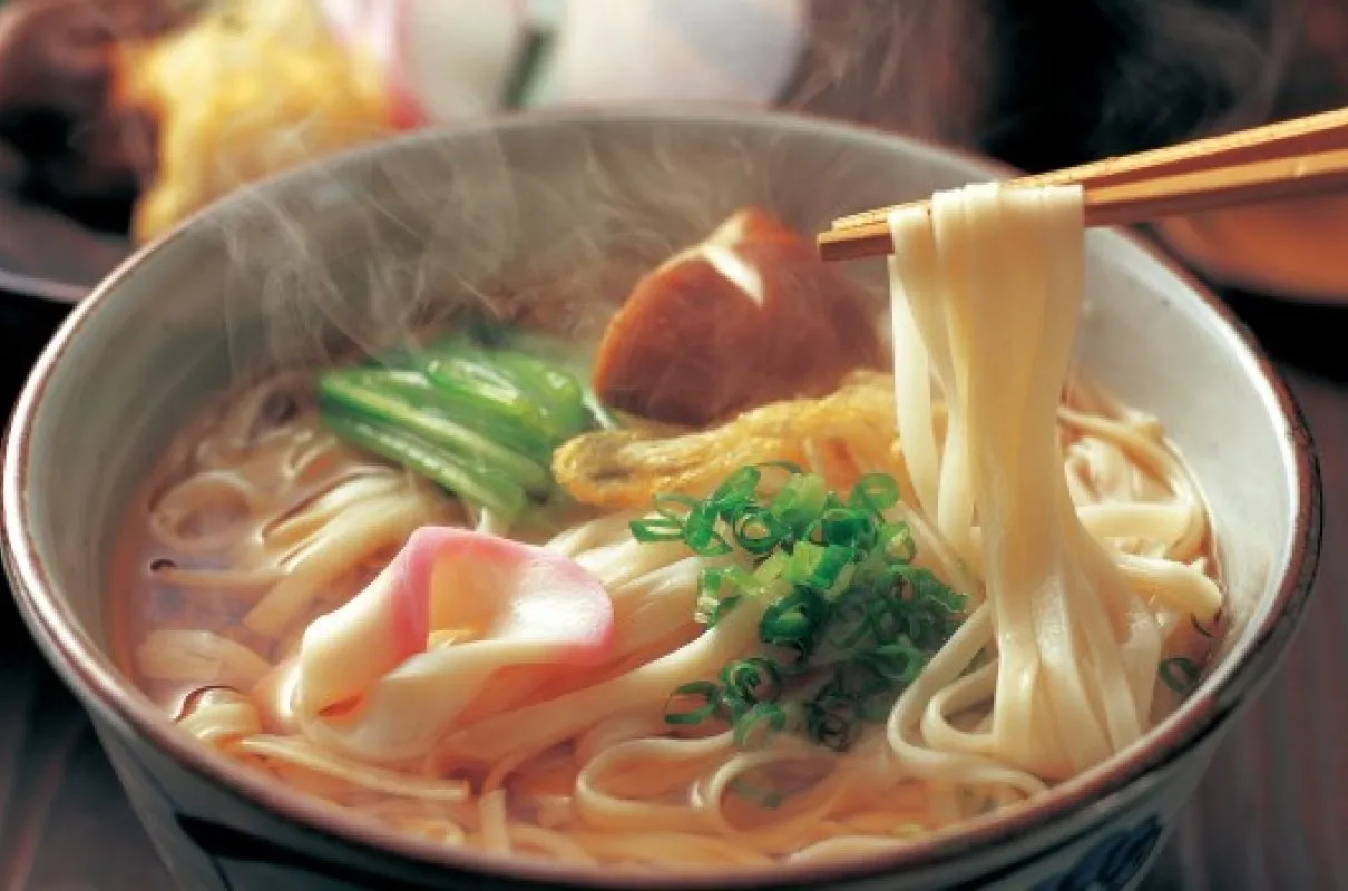 Gorący bulion z makaronem udon, zieloną cebulką, kawałkami ryby i grzybami. Oto jak gotować makaron udon.