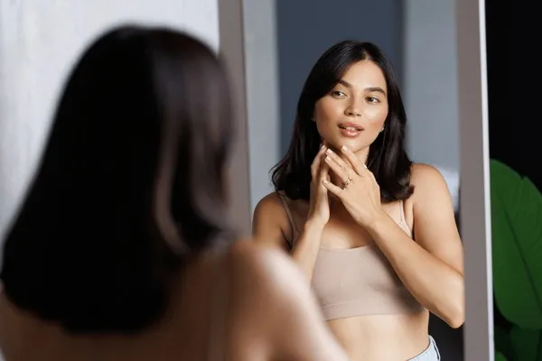 Kobieta przymierzająca biustonosz w lustrze