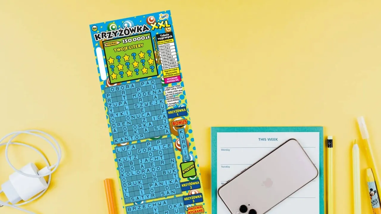 Krzyżówka XXL z szansą na wygraną 150 000 zł leży obok telefonu i planera.