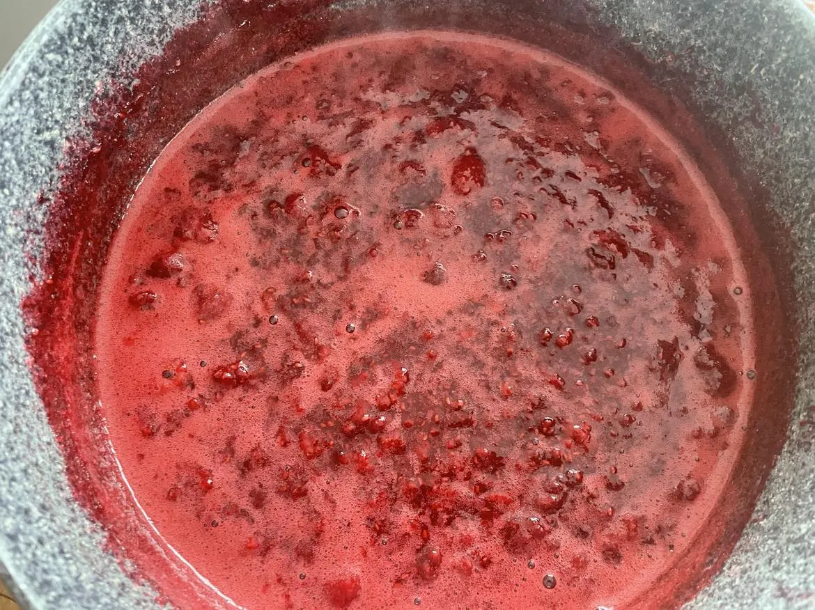 Robienie soku malinowego w garnku, maliny zasypane cukrem