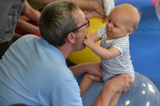 8-miesięczne dziecko marudzące na rękach rodzica