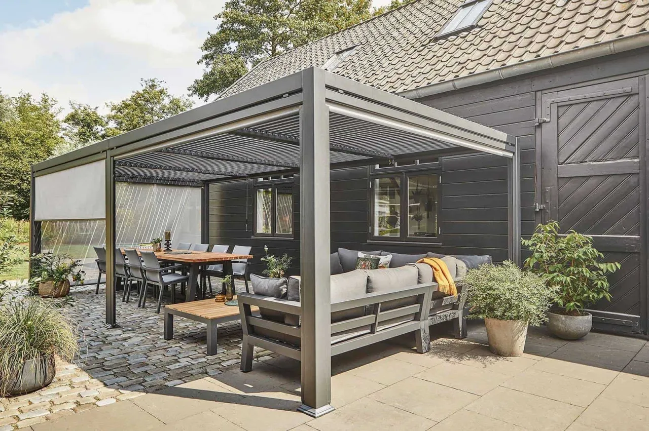 Nowoczesna pergola w ogrodzie z wygodną strefą wypoczynkową i jadalnianą. Idealne miejsce na relaks i spotkania.