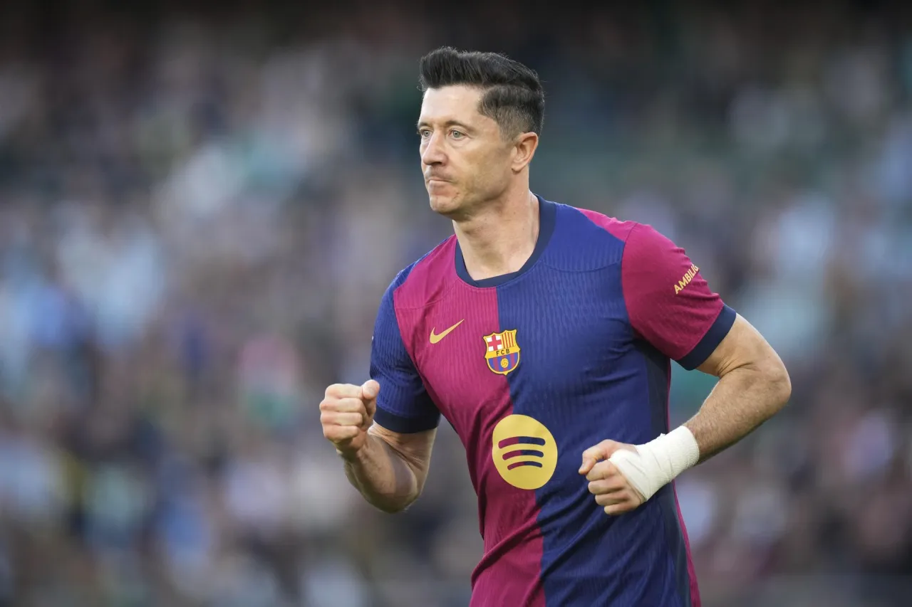 Robert Lewandowski w koszulce Barcelony, biegnie po boisku. Fani zastanawiają się, ile zarabia Lewandowski na miesiąc.