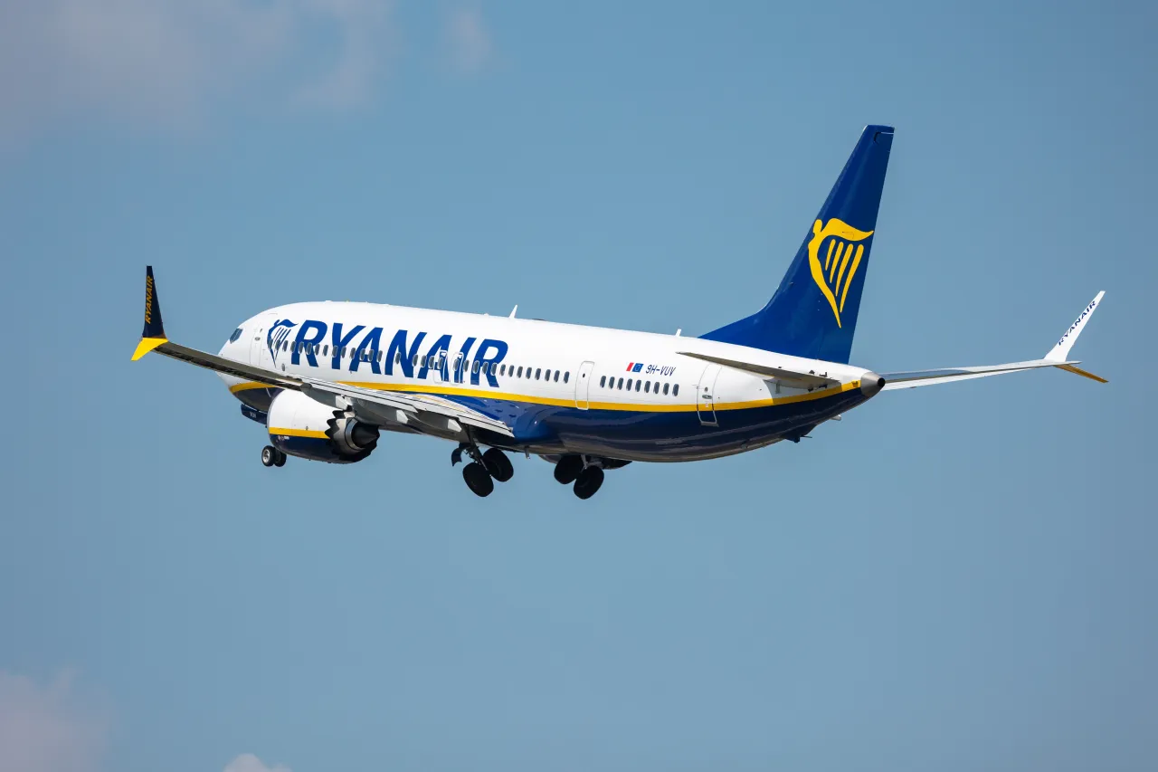 Samolot Ryanair wznosi się na błękitne niebo. Te tanie linie lotnicze oferują podr&oacute;że po Europie.