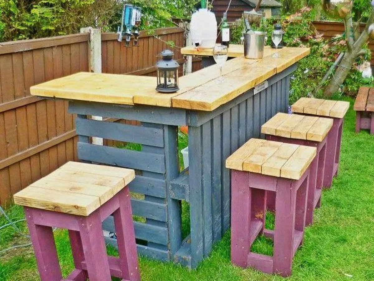 Oto pomysł, co można zrobić z palet do ogrodu: bar z hokerami, idealny na letnie wieczory.