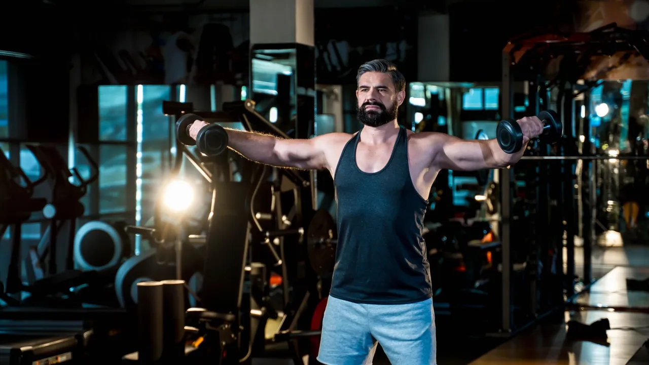 Frau macht Seitheben mit Kurzhanteln für breite Schultern