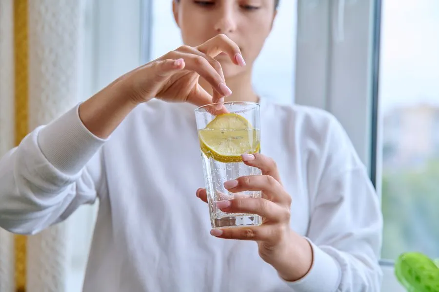 kobieta pije wodę gazowaną z cytryną, odchudzanie