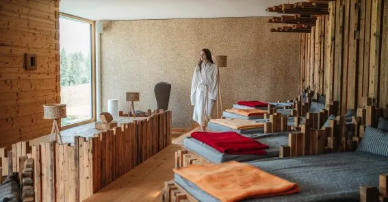 Alpine Spa-Anwendung mit Kräuterstempeln und Naturprodukten