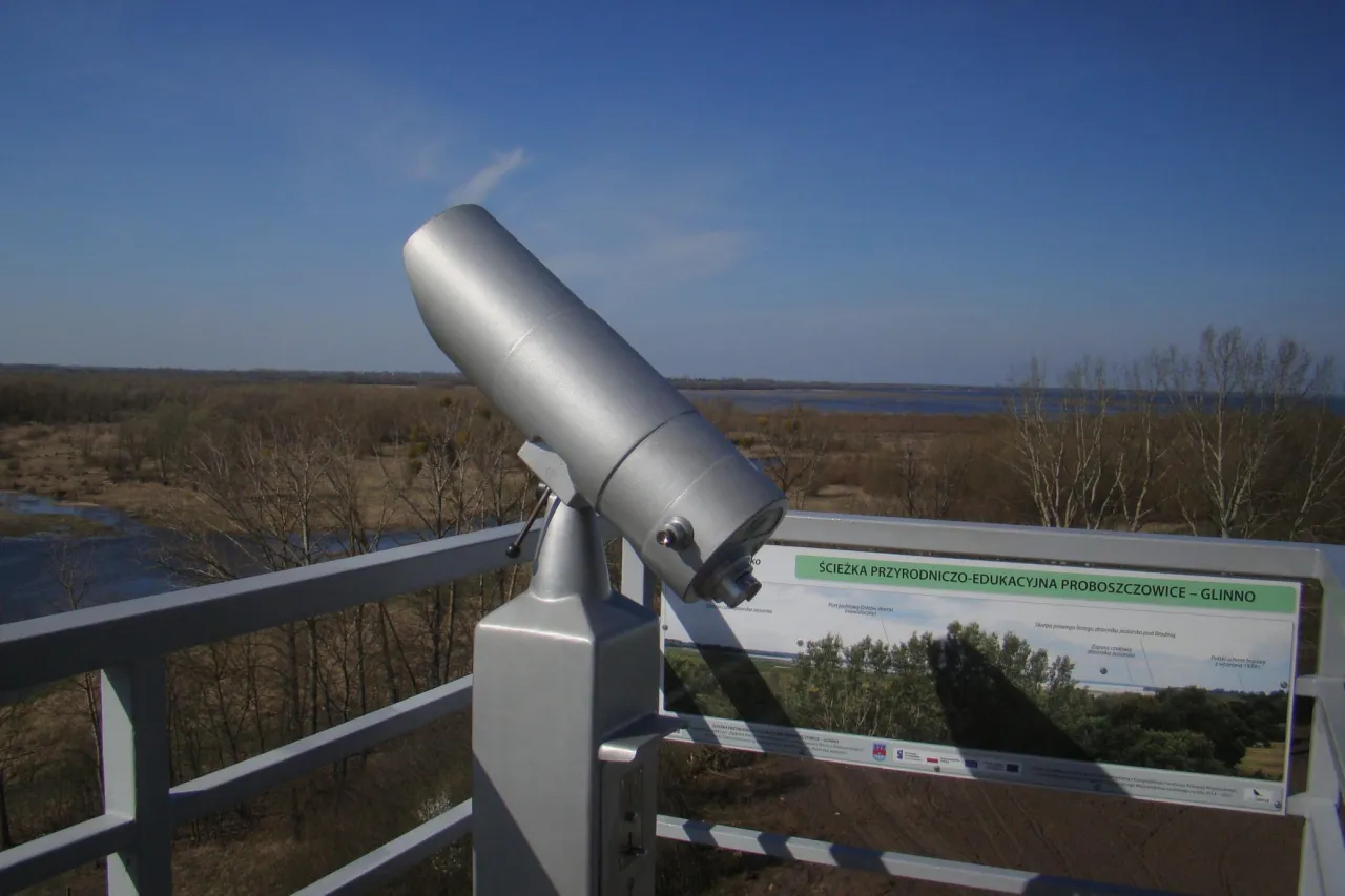 Luneta widokowa na platformie obserwacyjnej w rezerwat przyrody Jeziorsko. W tle rozległy krajobraz z wodą i drzewami.