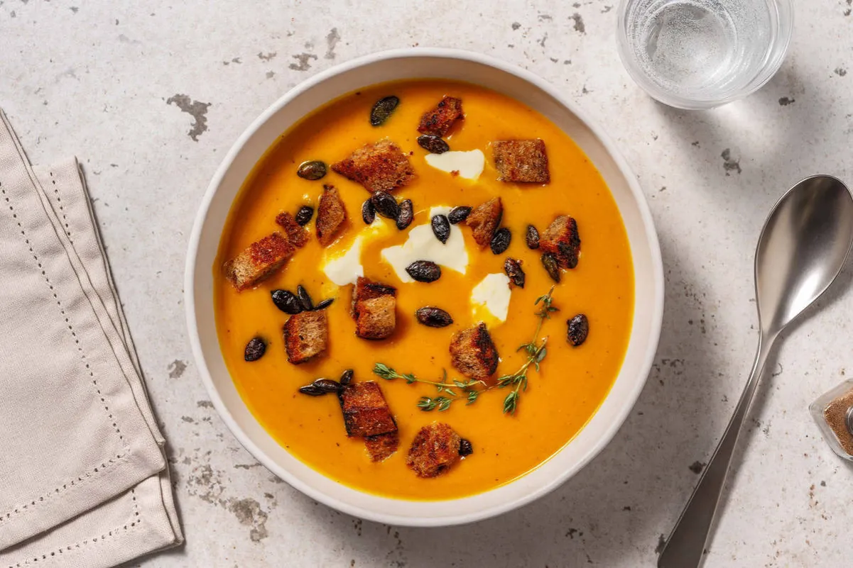 Soupe garnie de croûtons, herbes et graines