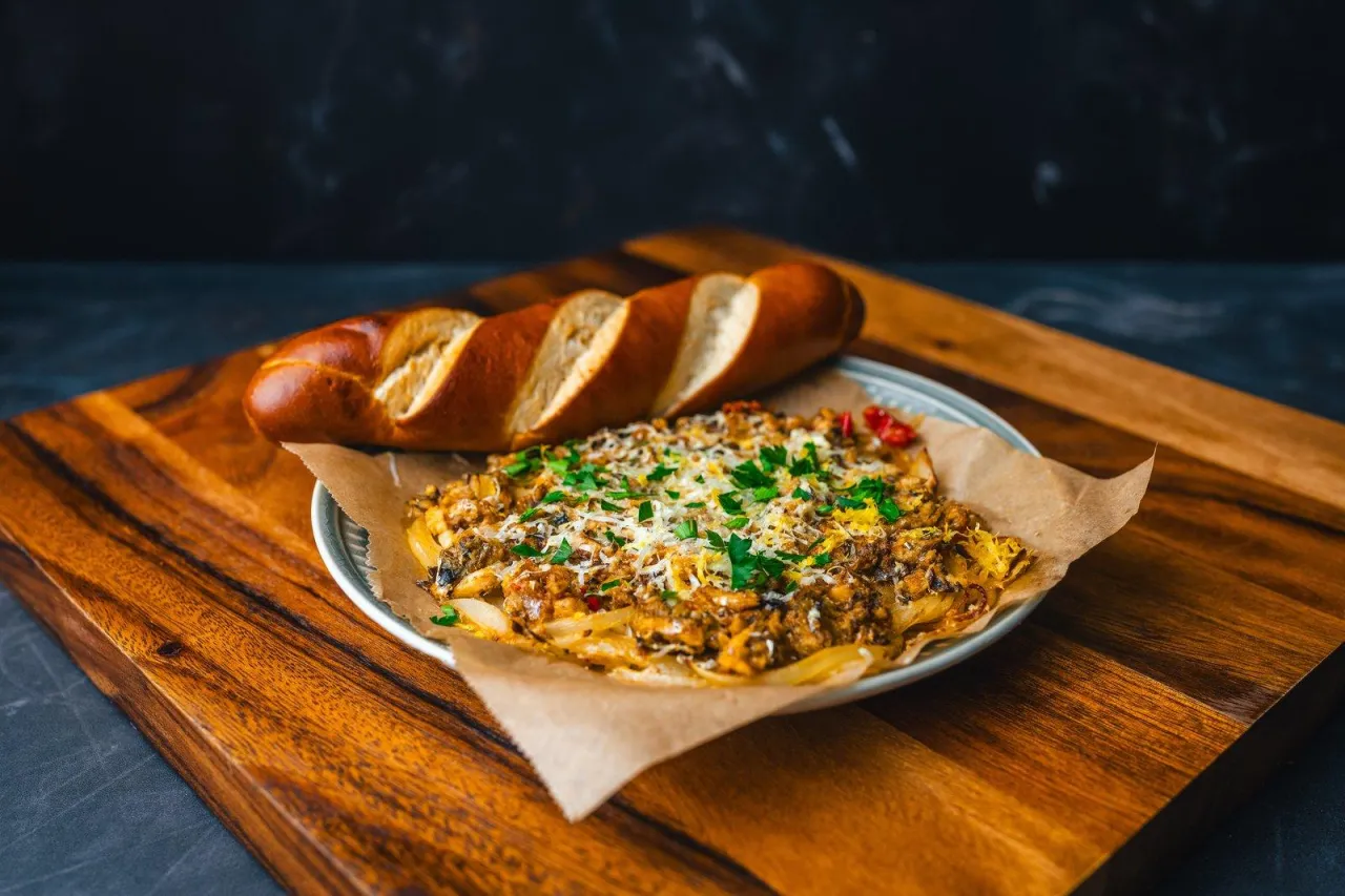 Zapiekanka z mięsem i warzywami, posypana serem i natką, idealna z bułką. Oregano do jakich potraw? Do tej zapiekanki!