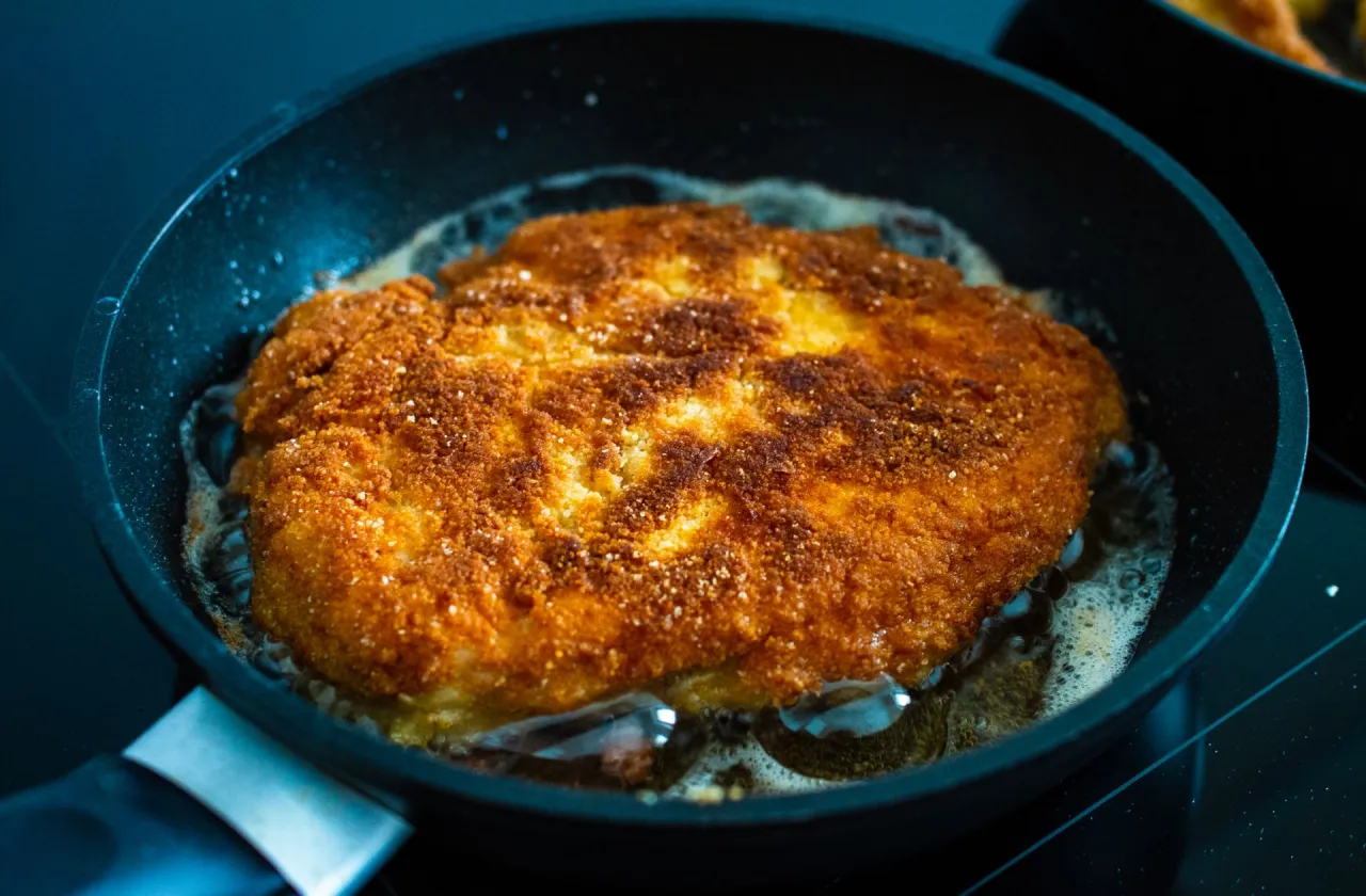 Smażący się kotlet schabowy na patelni