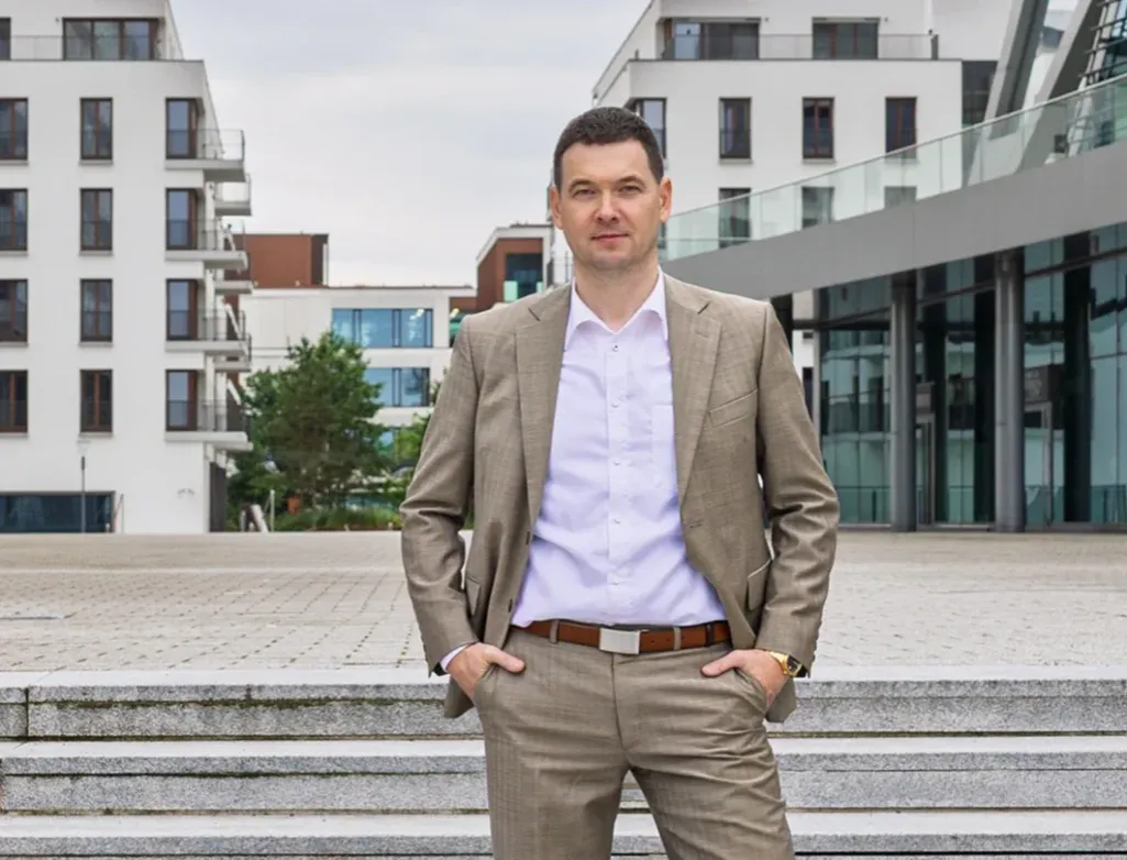 Osoba zastanawiająca się nad karierą agenta nieruchomości, z pytajnikiem nad głową, w tle miasto