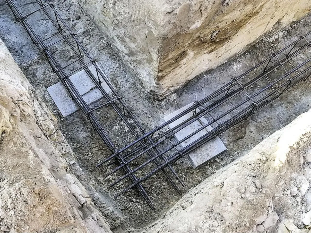 Gotowe zbrojenie na fundament, stalowe pręty ułożone w wykopie, czekają na zalanie betonem. To kluczowe, jakie zbrojenie na fundament, by budynek był stabilny.