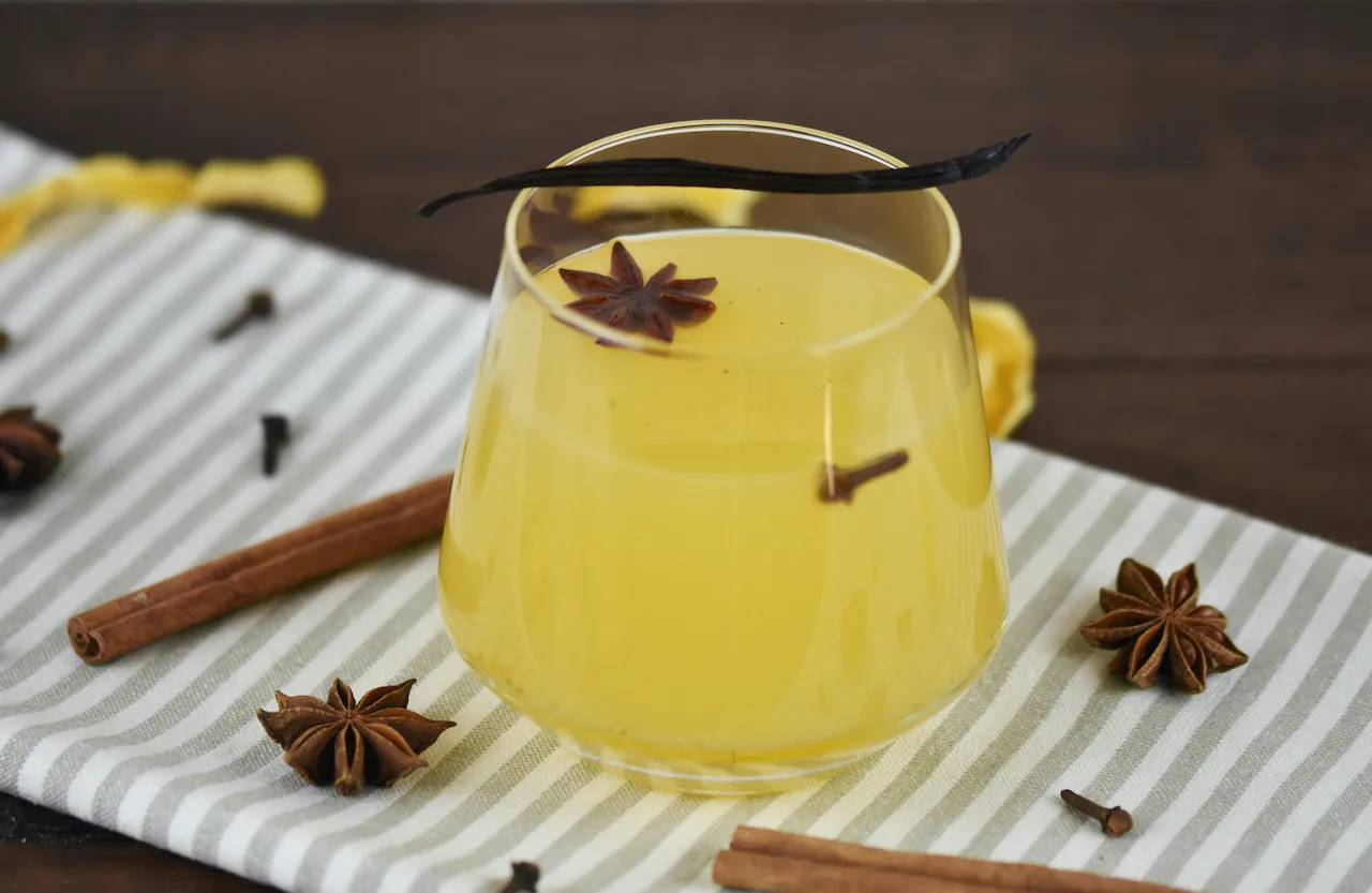 Glas weißer Glühwein mit Vanille und Zitronenscheiben