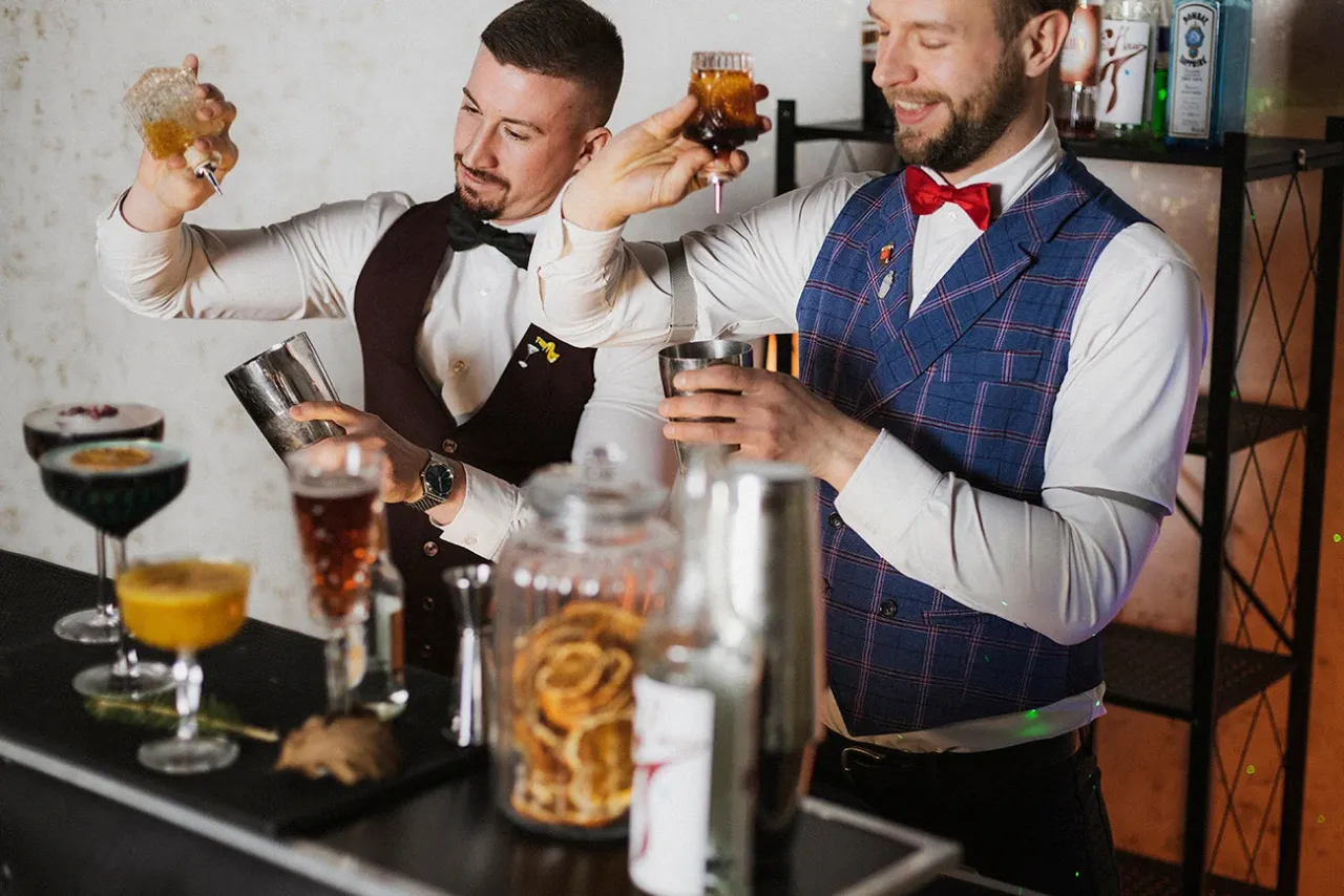 profesjonalny barman przygotowujący koktajl w eleganckim barze