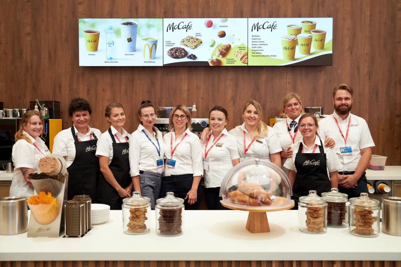 Zespół McCafe, uśmiechnięty i gotowy do pracy. Ich kod zawodu kucharz jest widoczny na fartuchach.