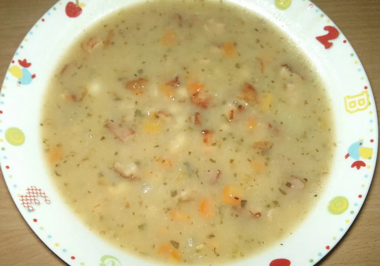 Gęsta zupa fasolowa z kawałkami wędzonki i warzyw. Idealna na obiad, a do tego co dodać do zupy fasolowej? Może majeranku!