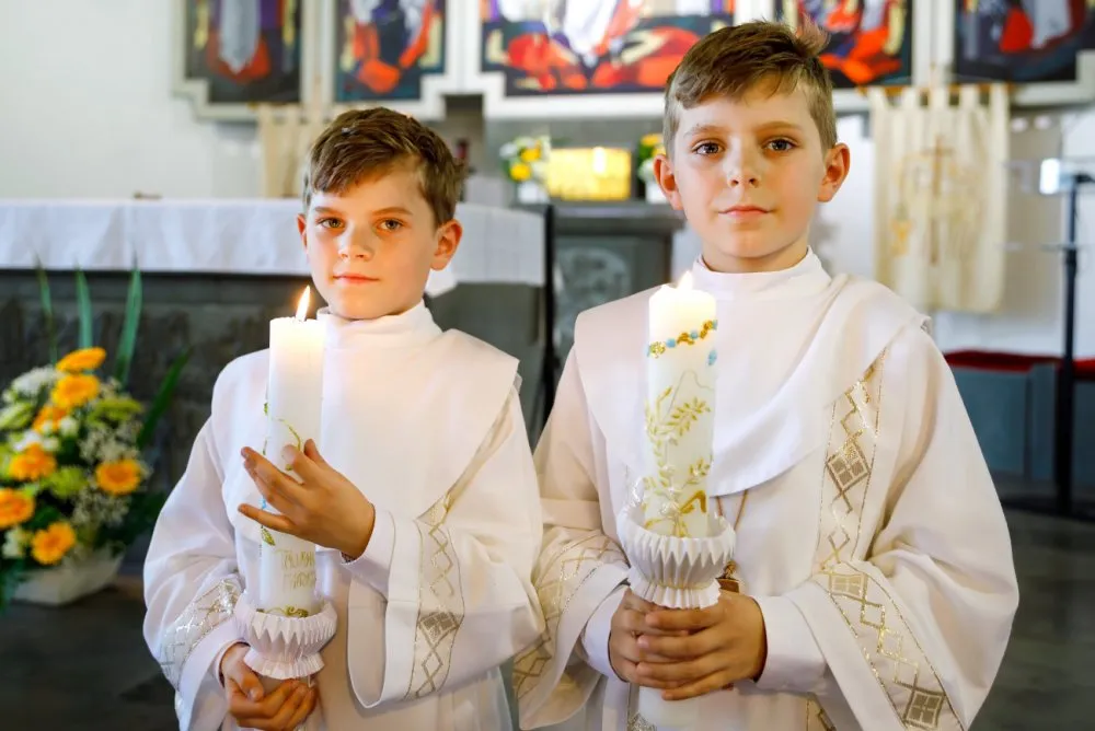 dziecko z świecą komunijną w kościele