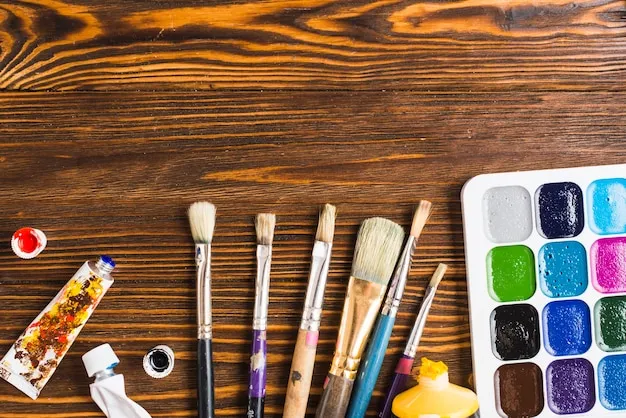 materiały plastyczne kredki farby pędzle na stole w pracowni artystycznej
