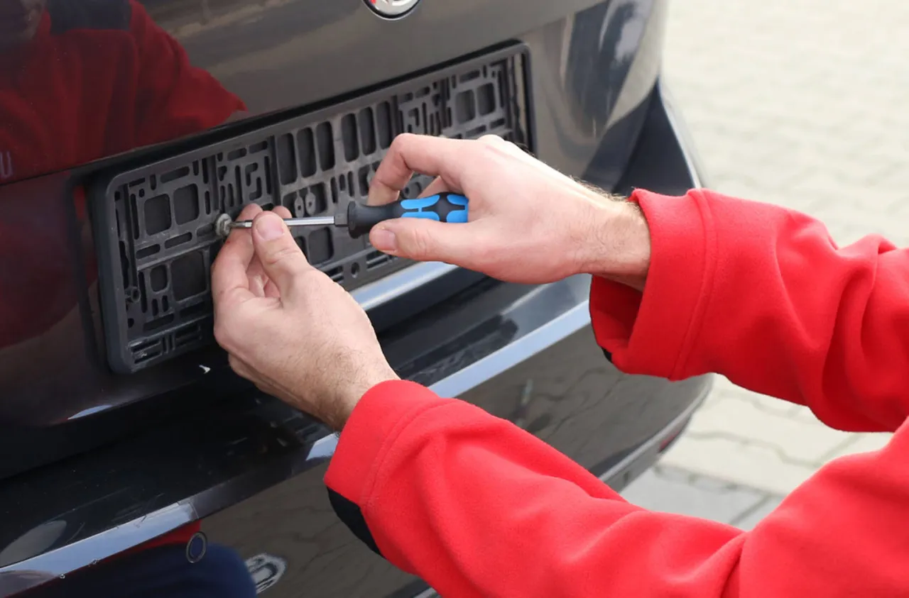 Demontaż tablicy rejestracyjnej z ramki zatrzaskowej