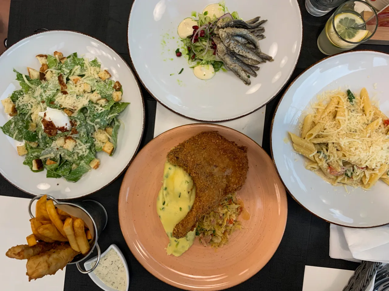 Pyszne dania, które podpowiedzą, gdzie zjeść w Dębkach: sałatka Cezar, smażone rybki, panierowany kotlet z puree i makaron.