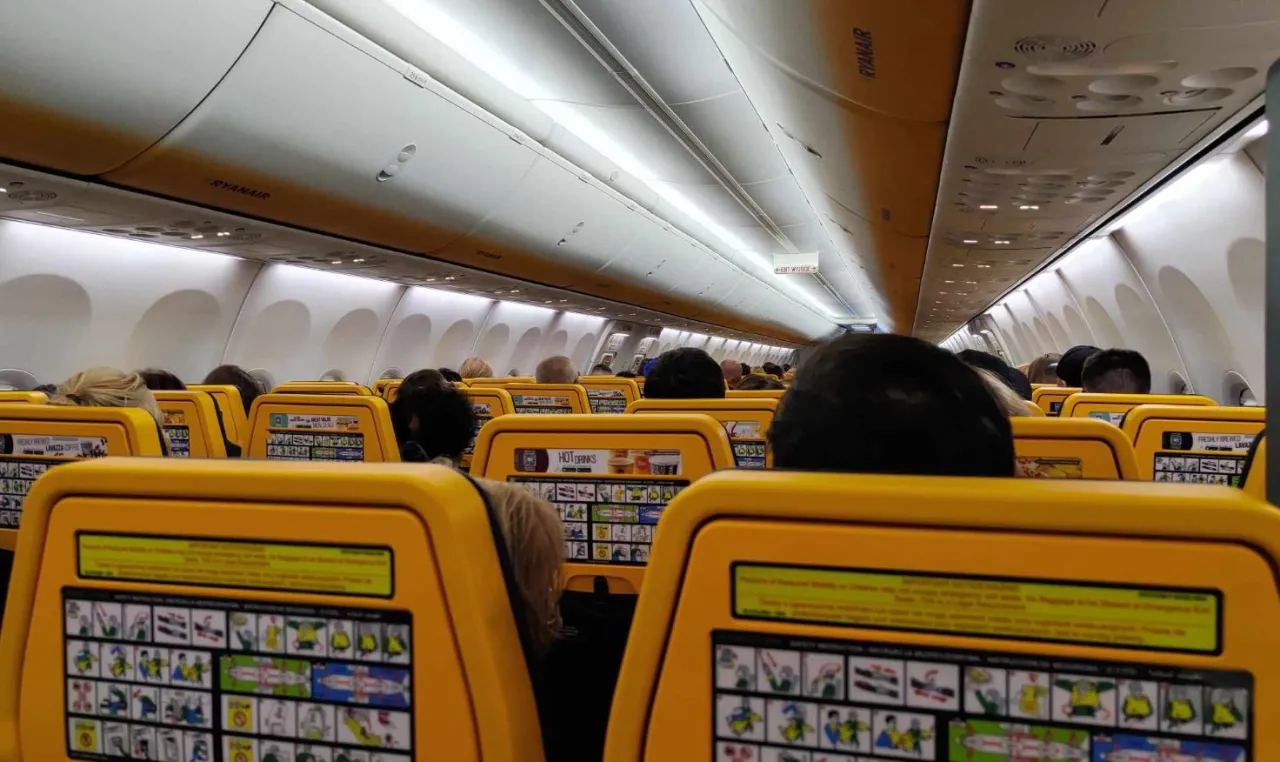 Wnętrze samolotu Ryanair, ż&oacute;łte siedzenia i instrukcje bezpieczeństwa. To właśnie linie Ryanair, znane z tanich lot&oacute;w.