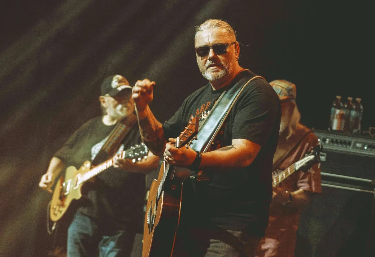 Charyzmatyczny wokalista z gitarą, jakby śpiewał 