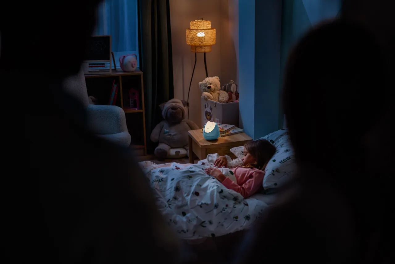 rodzic uspokaja dziecko w łóżku nocą