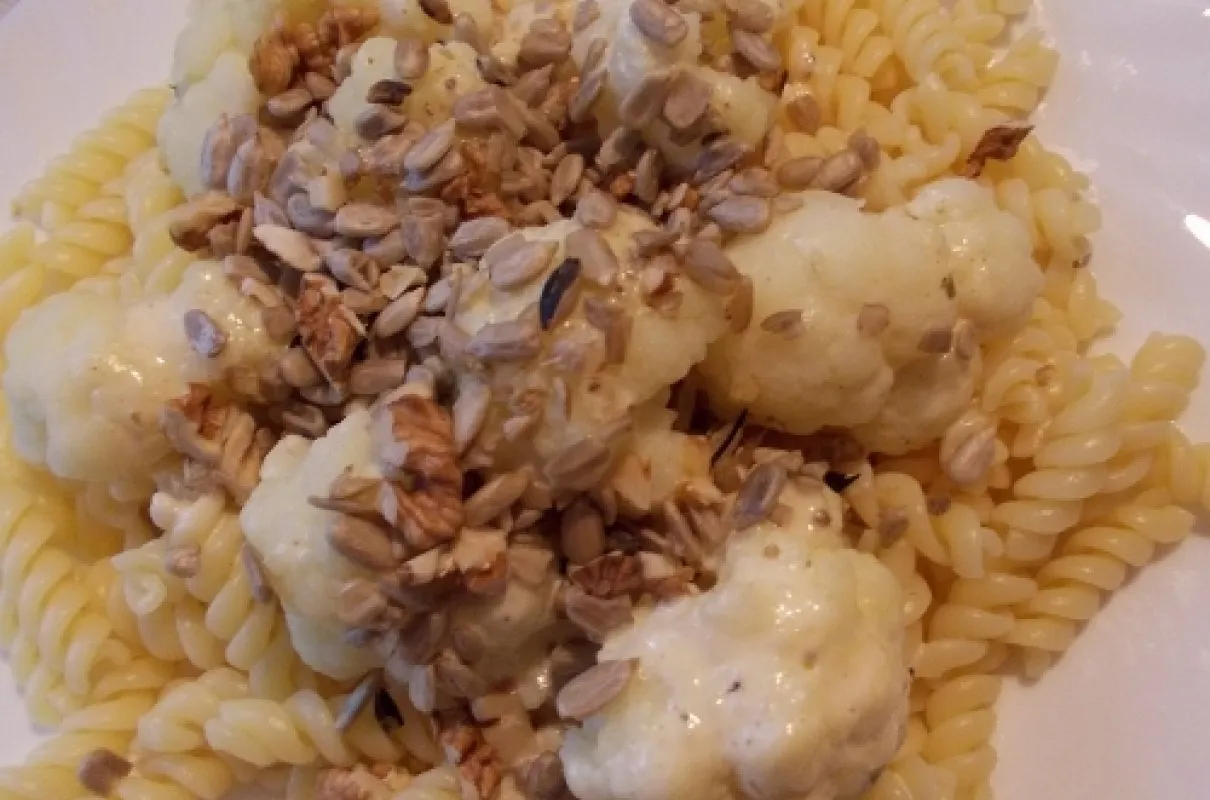Pyszny makaron z kalafiorem w sosie śmietanowym, posypany słonecznikiem i orzechami.