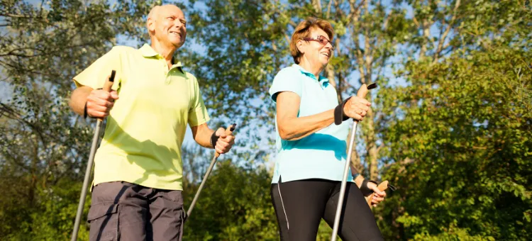 Seniorzy ćwiczący gimnastykę lub nordic walking