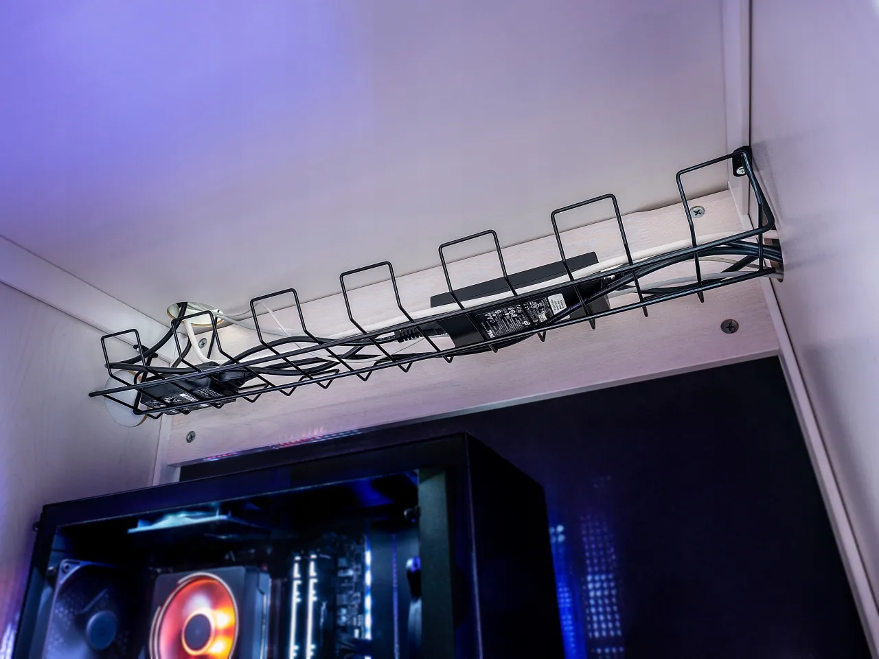 Metalowe zabezpieczenia na kable pod biurkiem porządkują plątaninę przewod&oacute;w, tworząc estetyczny kącik gamingowy.